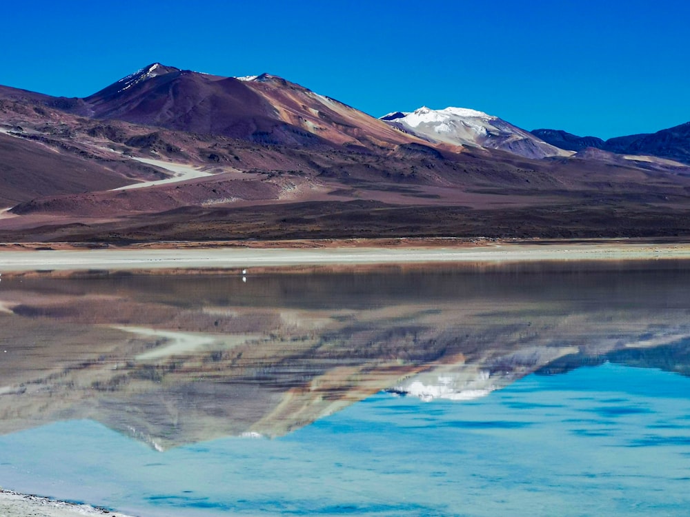 a body of water with mountains in the background