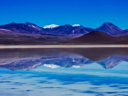 a body of water with mountains in the background