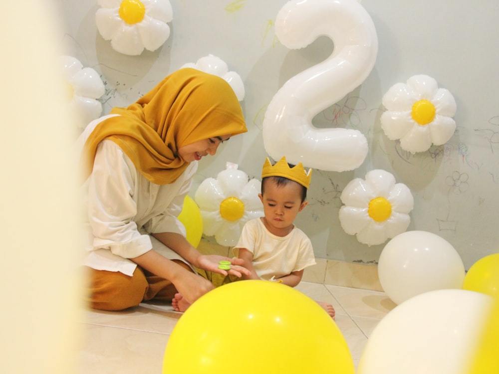 a person and a child sitting on a yellow balloon