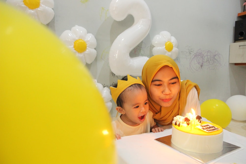 a person and a baby with a birthday cake