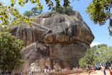 a large rock formation with people around it