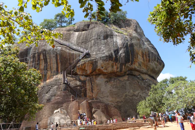 a large rock formation with people around it