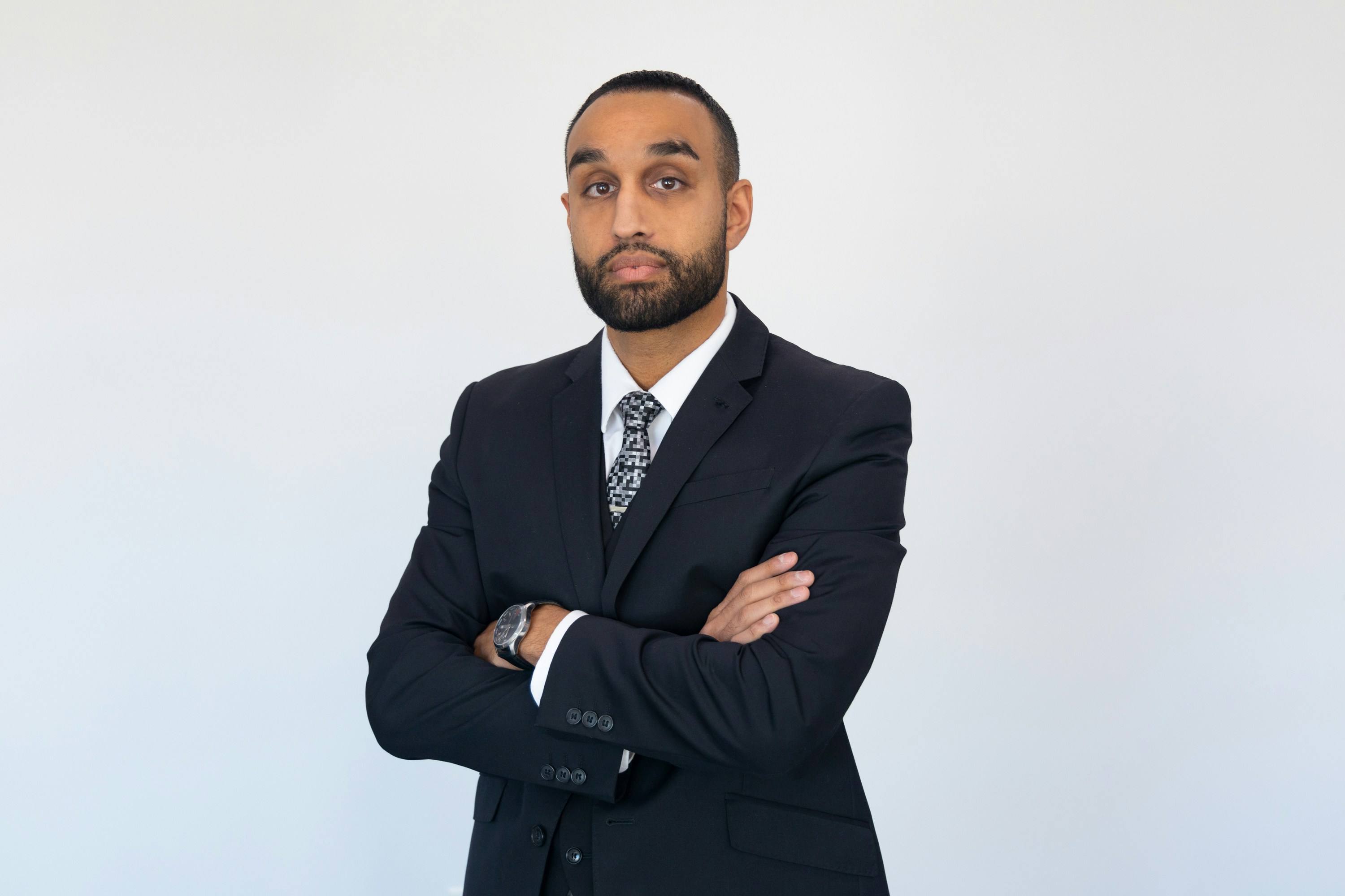 Tall male lawyer standing confidently in expensive suit with arm crossed</p><p dir=