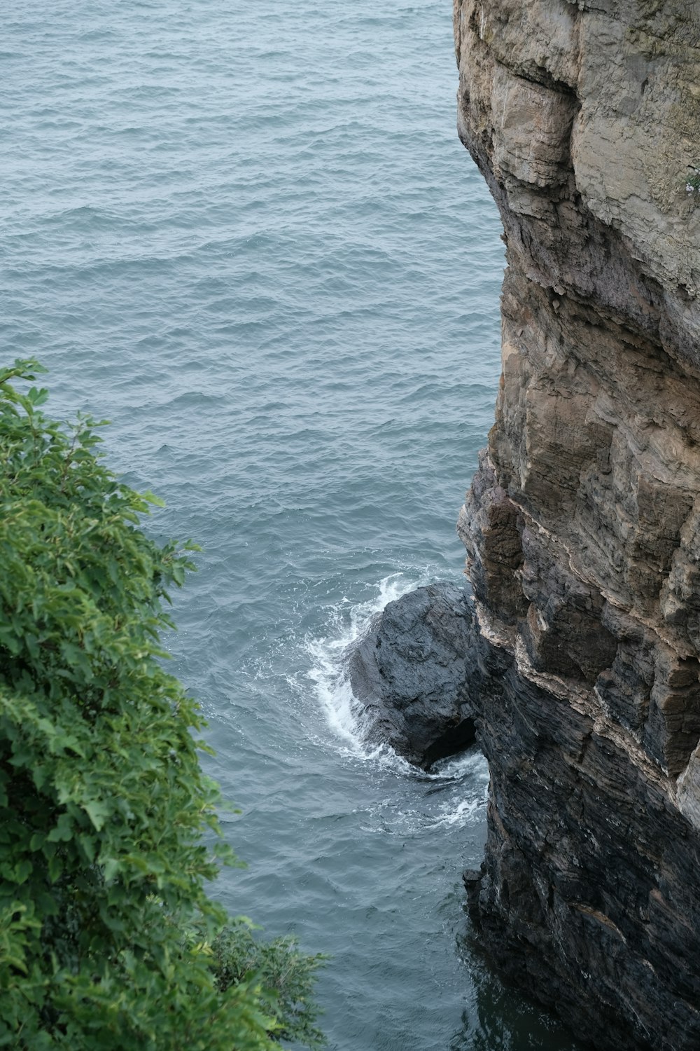 a rocky cliff with a body of water below