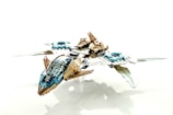 A detailed, futuristic toy spaceship made from interlocking plastic bricks, featuring blue and beige colors with transparent elements for the cockpit. The design includes sleek wings and intricate mechanical details, giving it a sci-fi appearance.