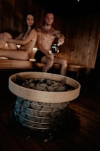 Two friends enjoying a sauna together, laughing and sharing stories, highlighting the social aspect of wellness.