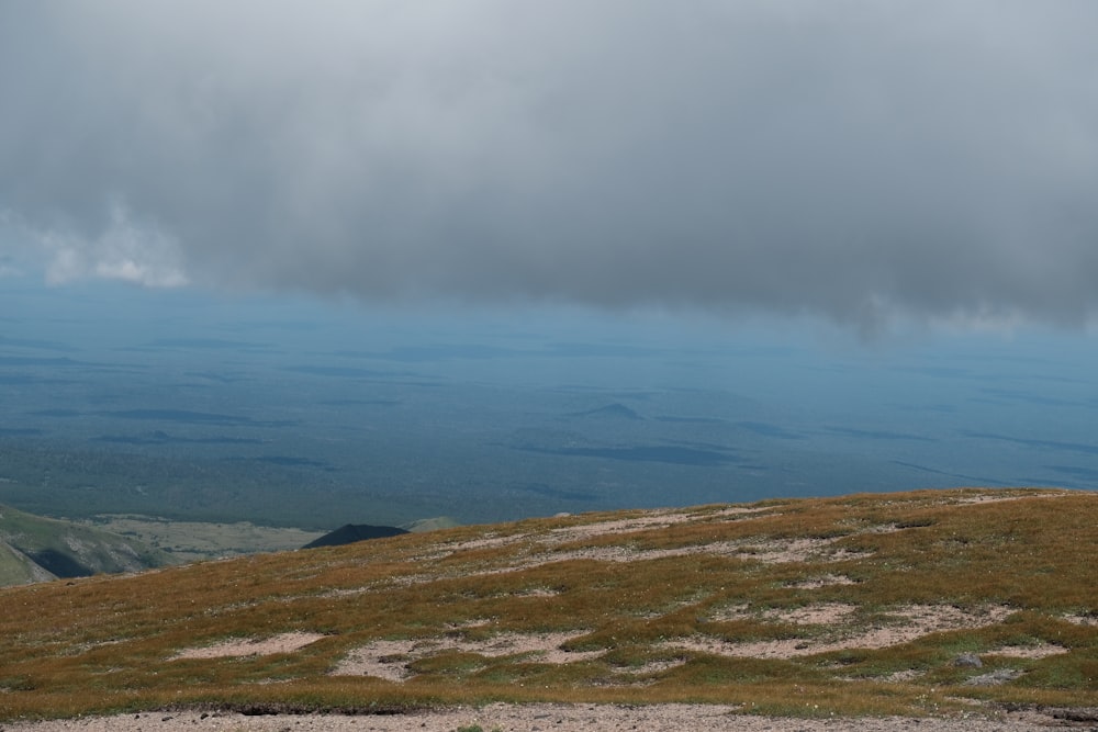 a landscape with hills and a body of water in the background