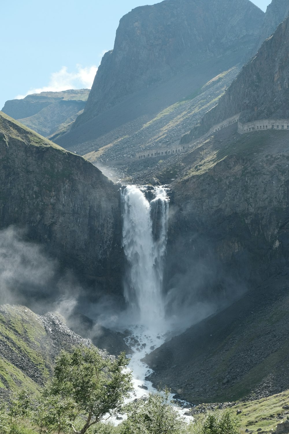 a waterfall in a valley between mountains