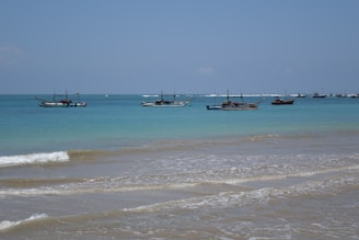 Crystal-clear turquoise waters with a small boat floating peacefully.