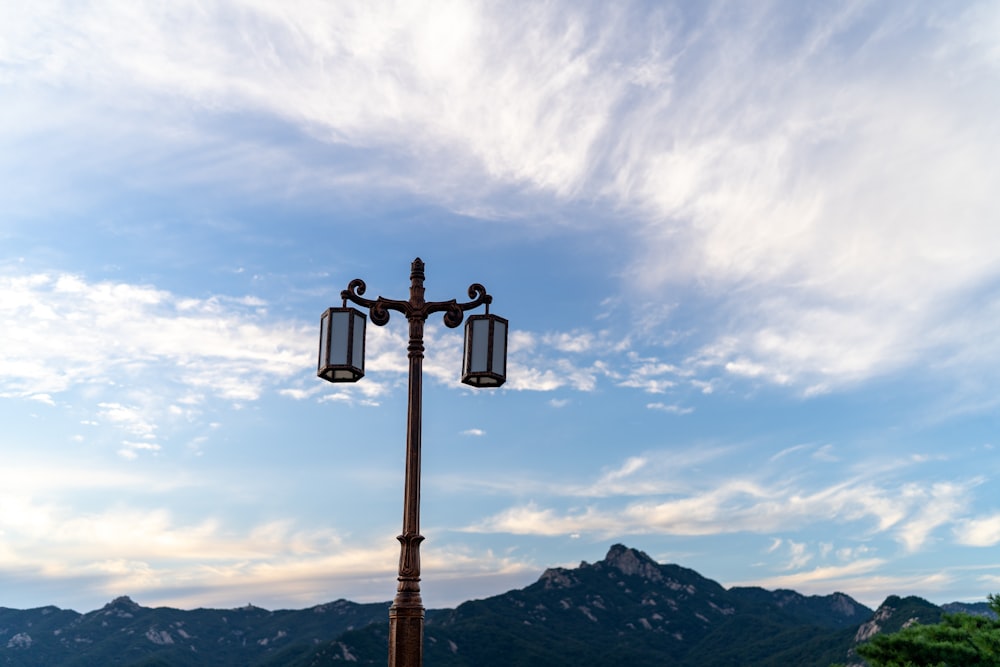 a light post with a mountain in the background