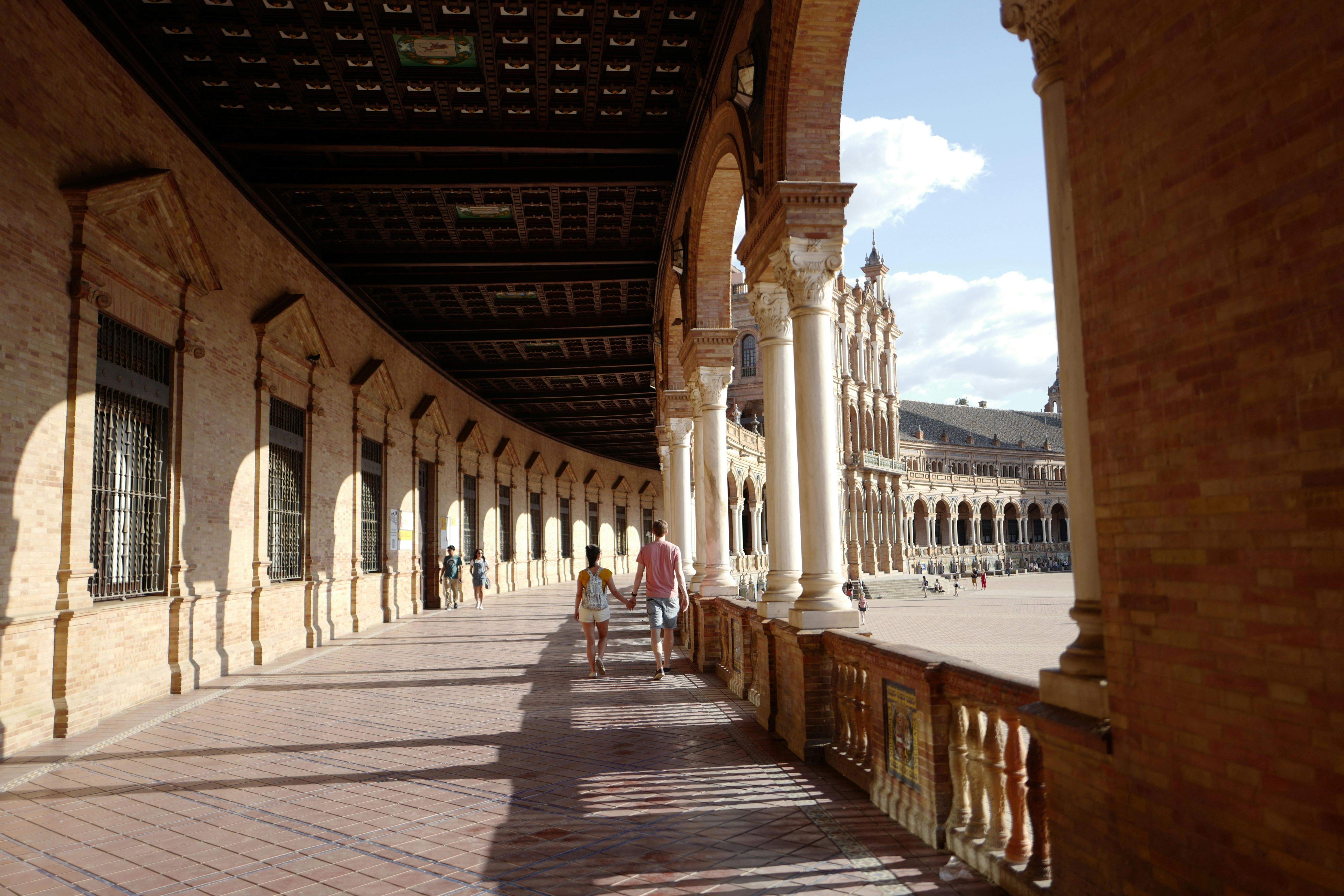 people walking on a brick walkway between buildings
