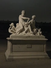 An elegant antique sculpture displayed on a wooden table with soft natural light.