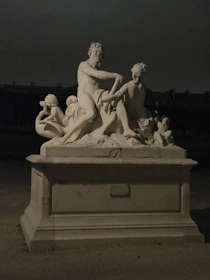 An elegant antique sculpture displayed in soft natural light highlighting its intricate craftsmanship.