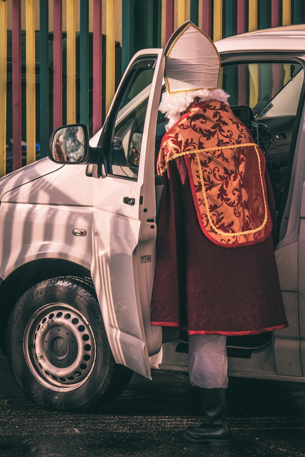 a person in a red dress standing next to a car