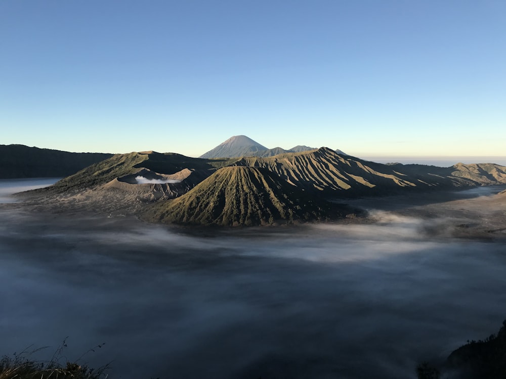 a body of water with mountains in the background with Mount Bromo in the background