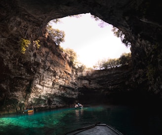 a group of people in a boat in a cave with Hamilton Pool Preserve in the background