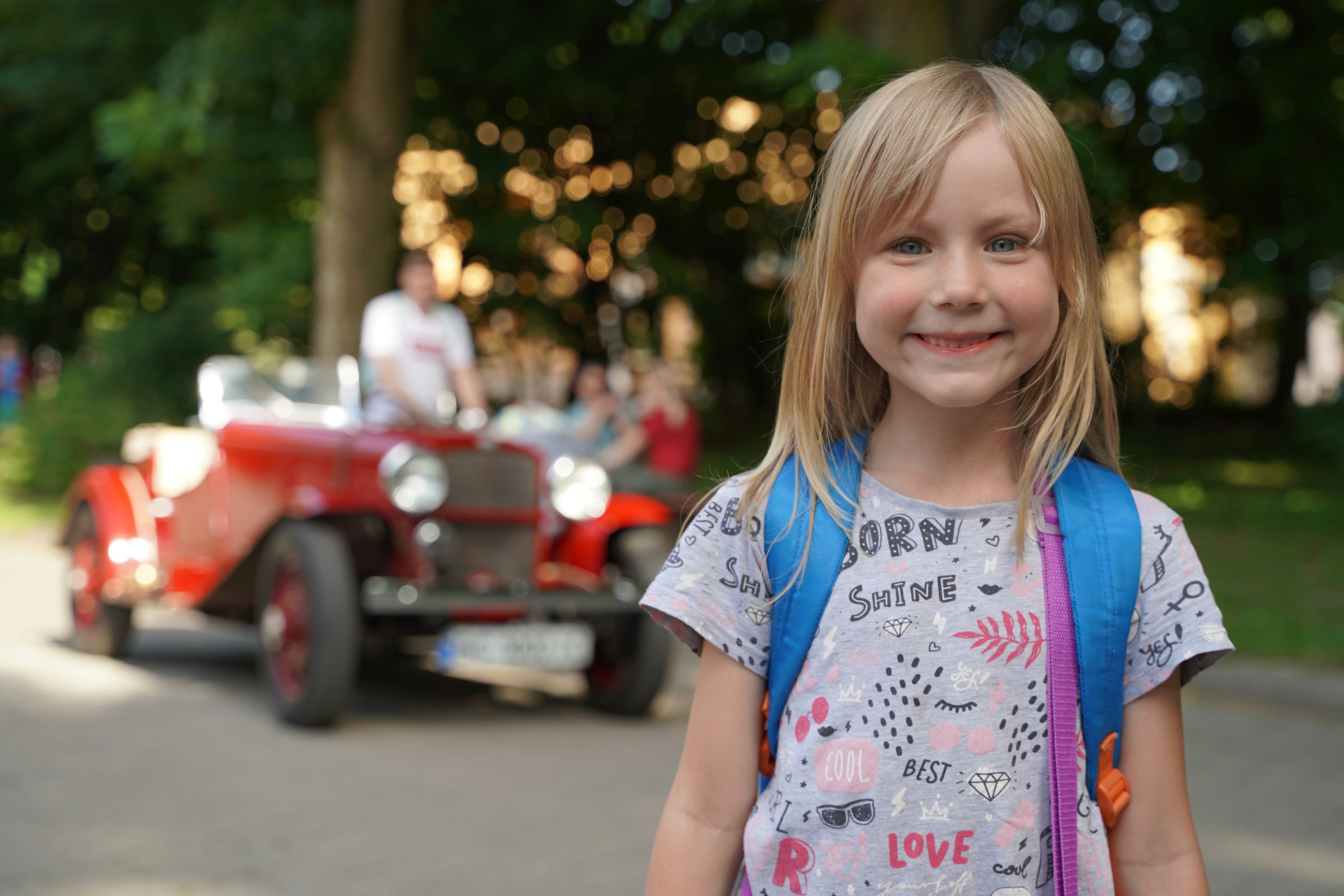 a girl smiling in front of a red truck