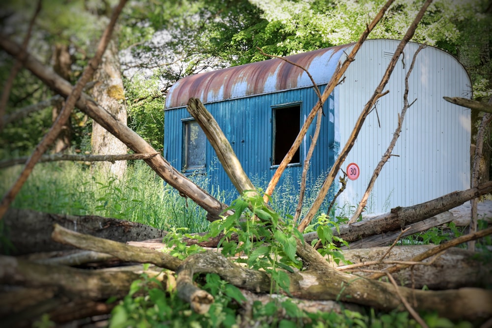 a blue and white building with a red roof surrounded by trees