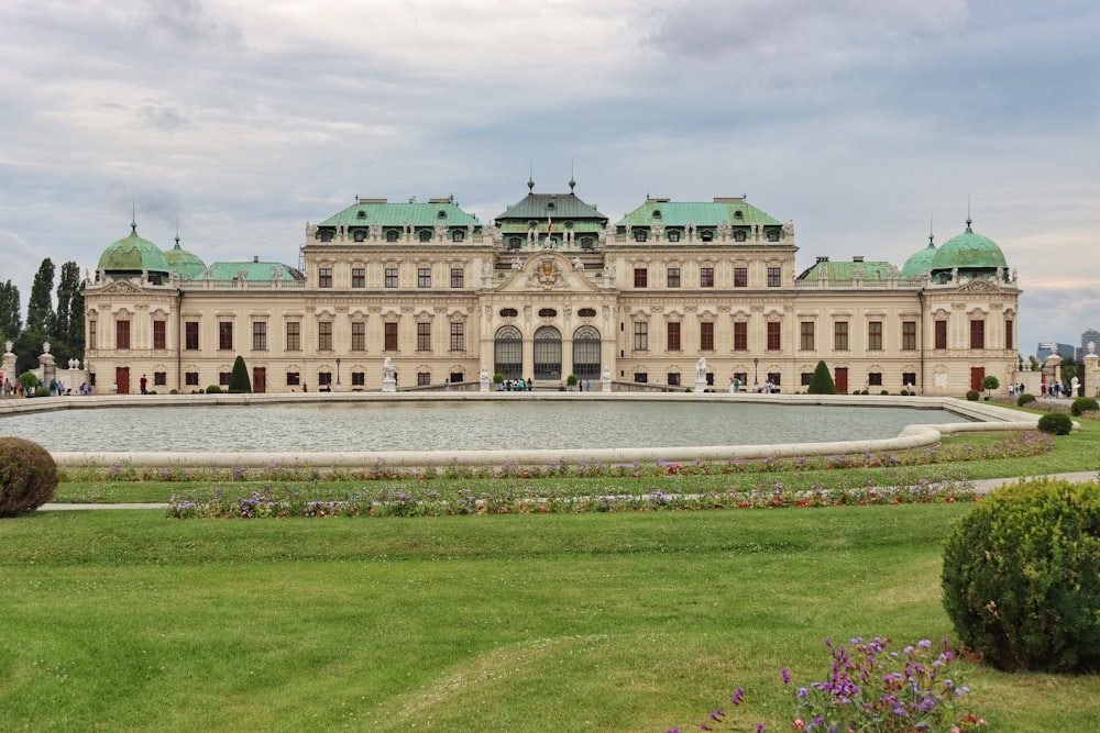 un grande edificio con una fontana di fronte con Belvedere, Vienna sullo sfondo