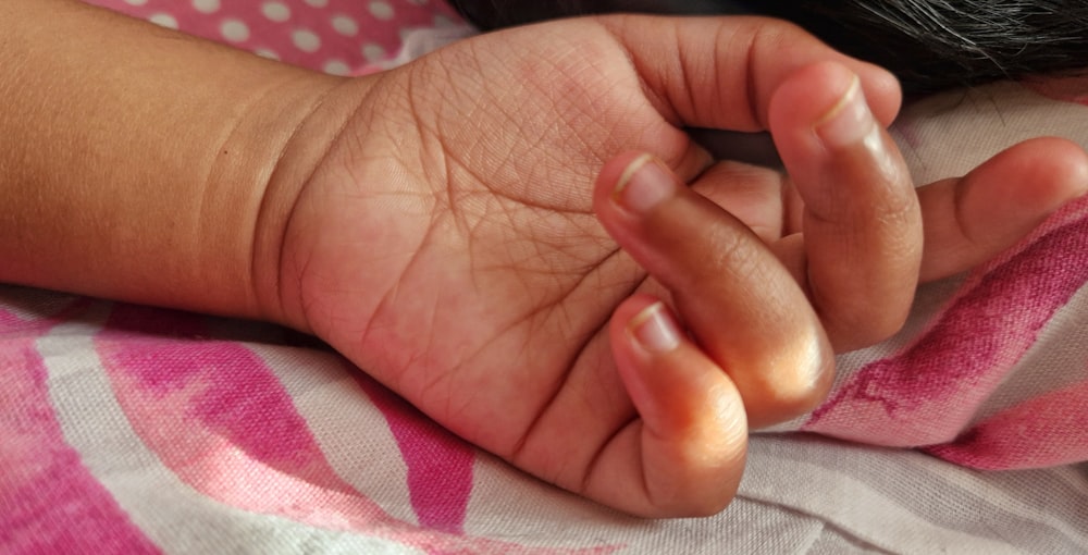 a close-up of a person holding a baby's hand
