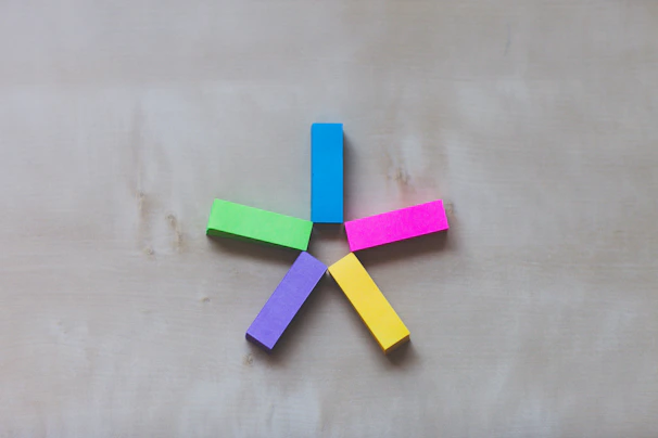 Close-up of colorful pastel blocks shaped like stars and circles on a soft pink background.