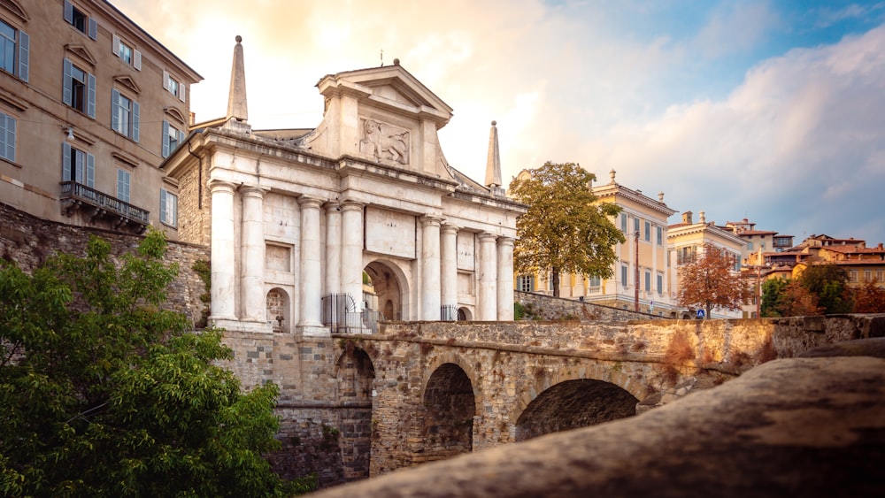 a stone bridge with a building in the background