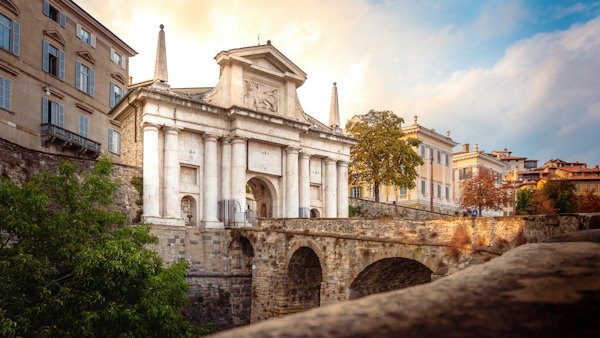 A stone bridge with a building in the background — Bergamo, Italy