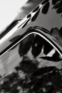 Close-up of a car surface with a glossy vitrification coating reflecting surroundings.
