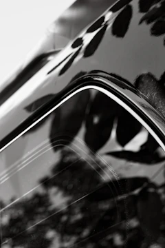 Close-up of a car surface with a glossy vitrification coating reflecting surroundings.