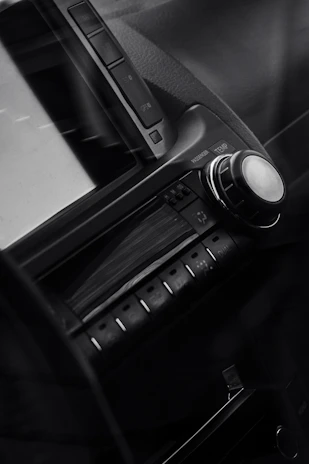 Close-up of a sleek SRS FM car radio display glowing inside a car dashboard.