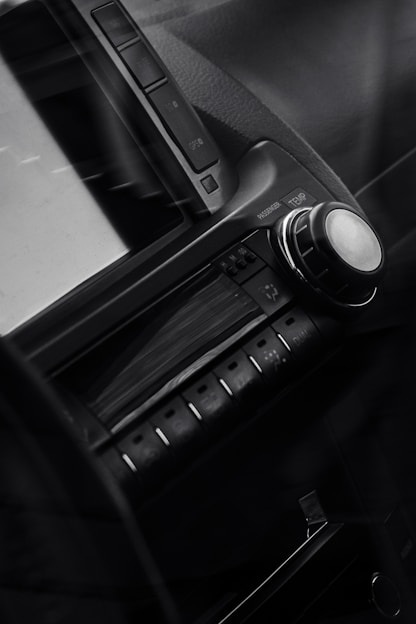 Close-up of a sleek car dashboard with glowing audio controls and speakers.