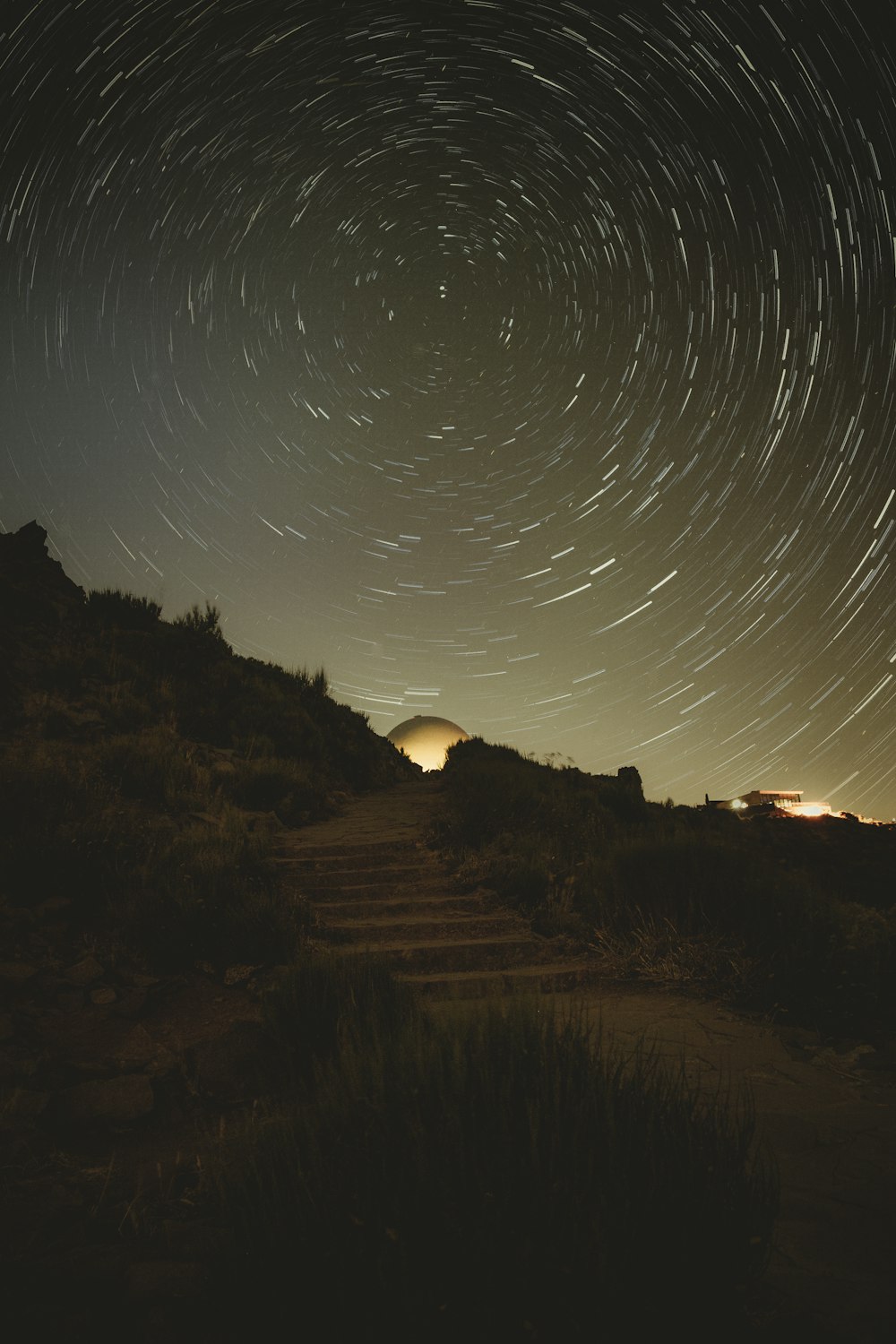 a river with a bridge and lights in the sky