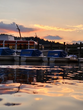 A serene sunset view over a traditional boat docked in Labuan Bajo harbor.
