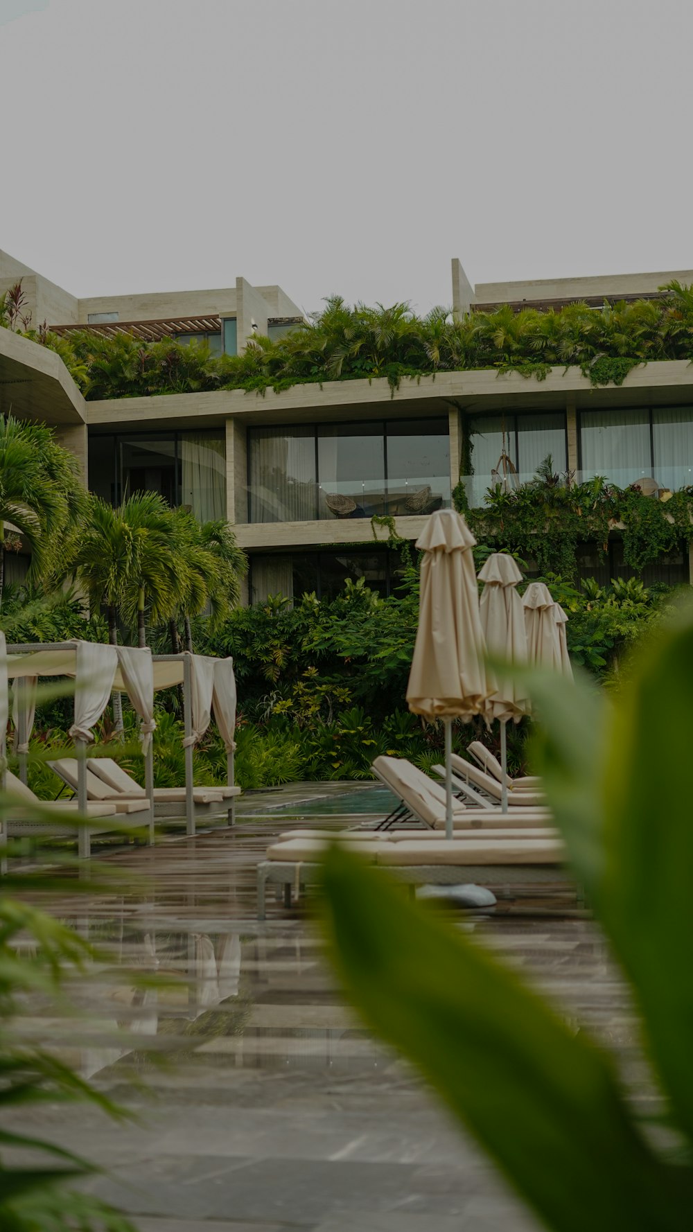 a building with a pool and umbrellas