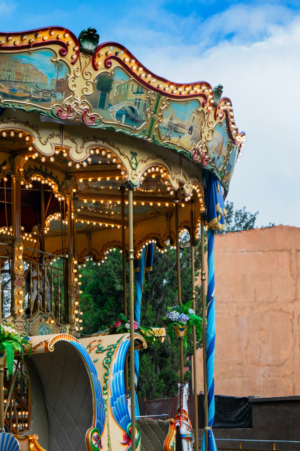 a colorful carousel with trees and blue sky