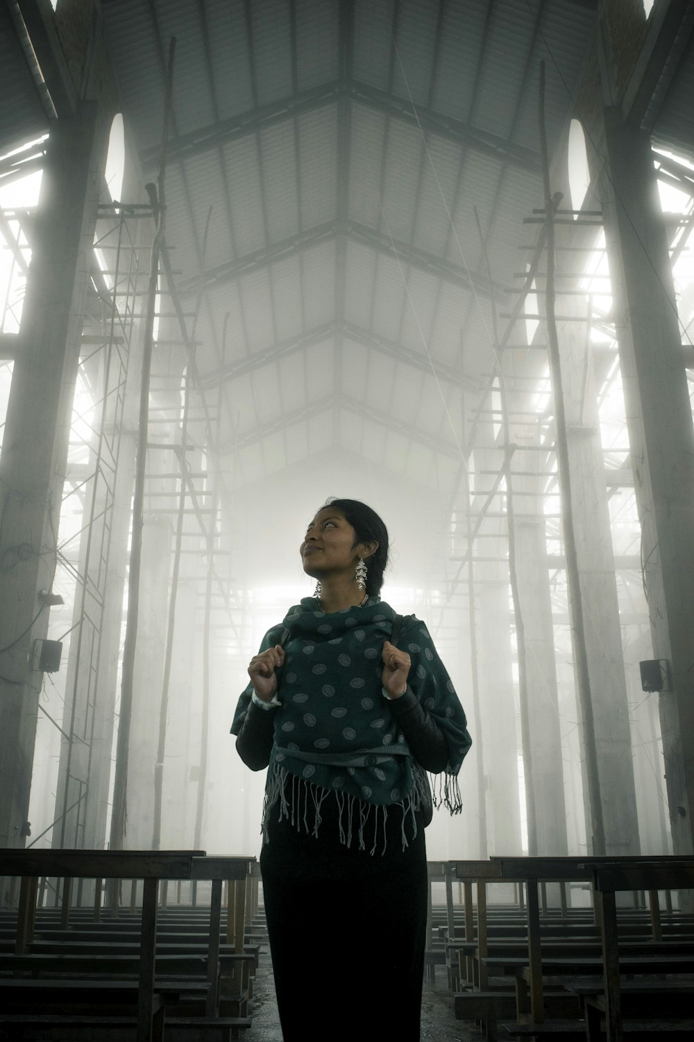 a woman standing in a room with tall columns