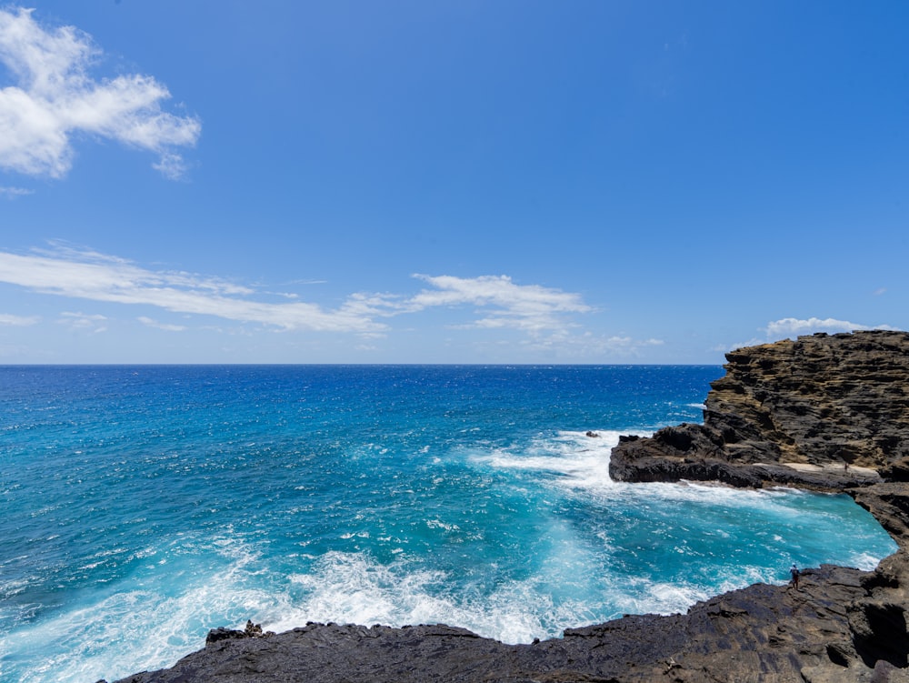 uma praia rochosa com água azul