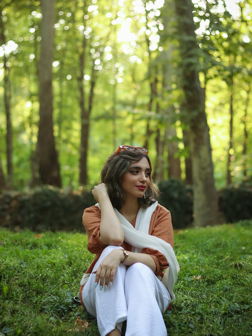 a woman sitting in a grassy area