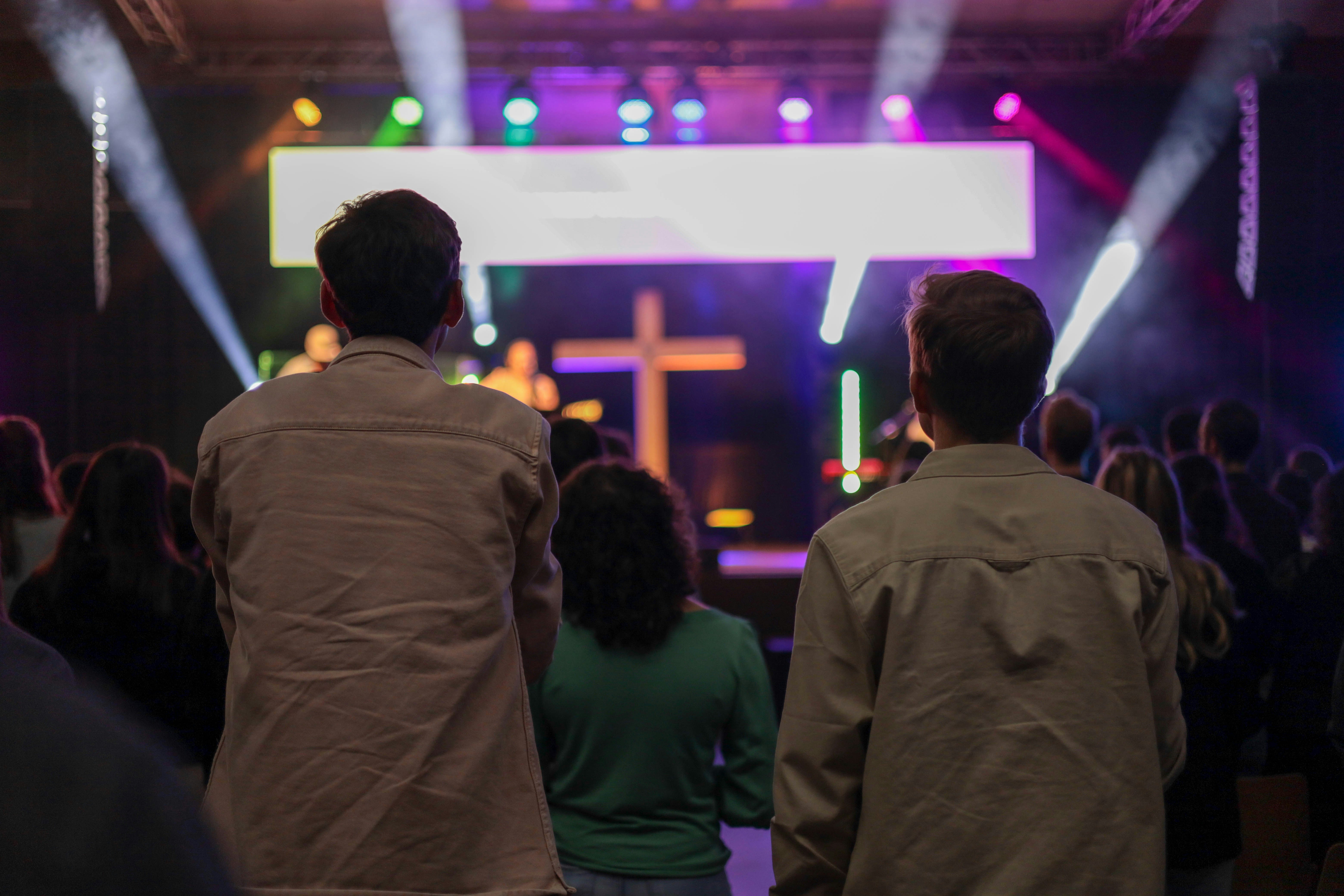 a group of people in a room with a stage and lights