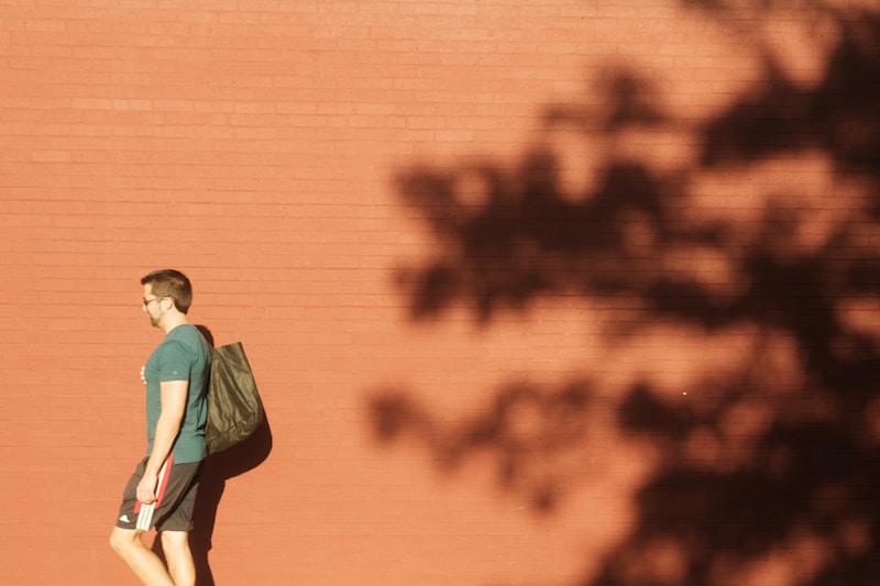 Man walking by brick wall