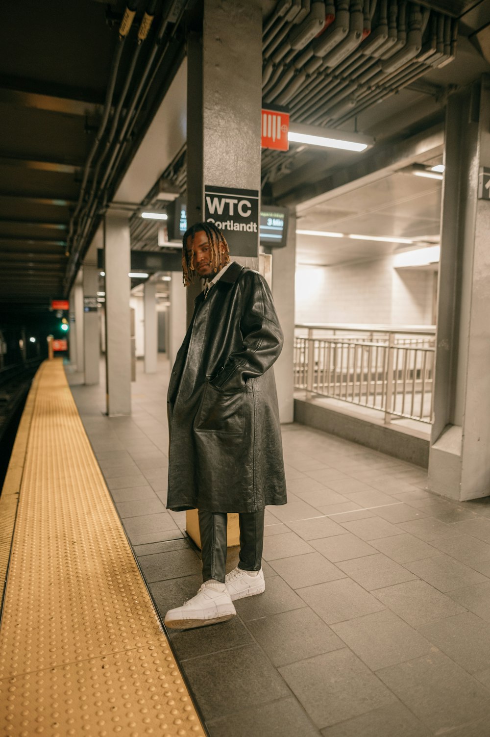 a person in a coat standing in a train station