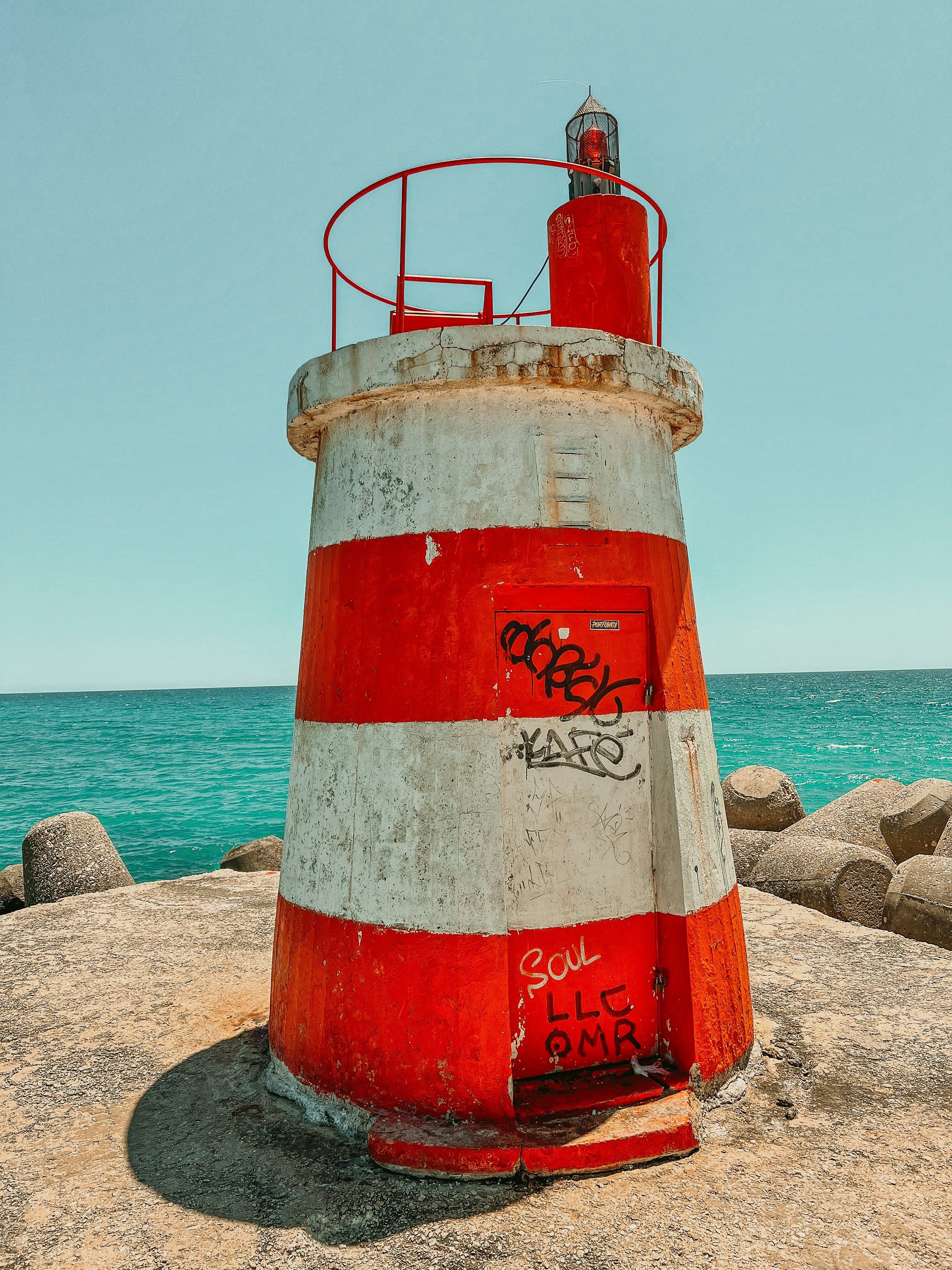 Una boca de incendios roja y blanca en una playa