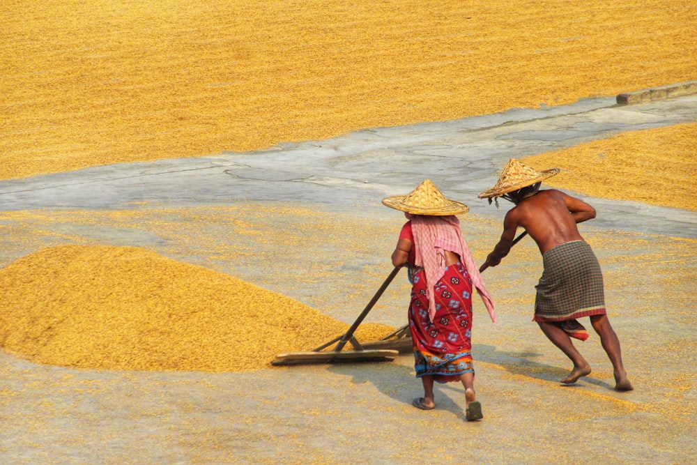 a couple of people carrying hats