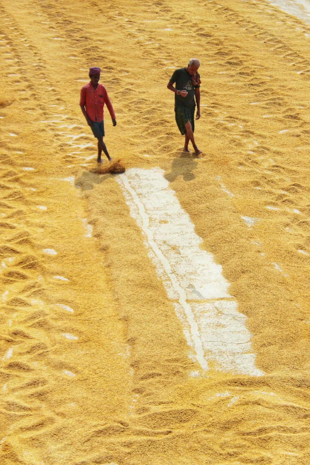 Due uomini che camminano nella sabbia