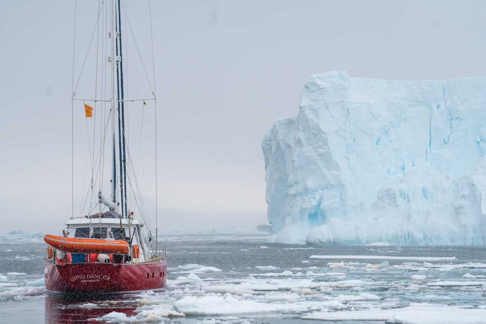 a boat in the water by an iceberg