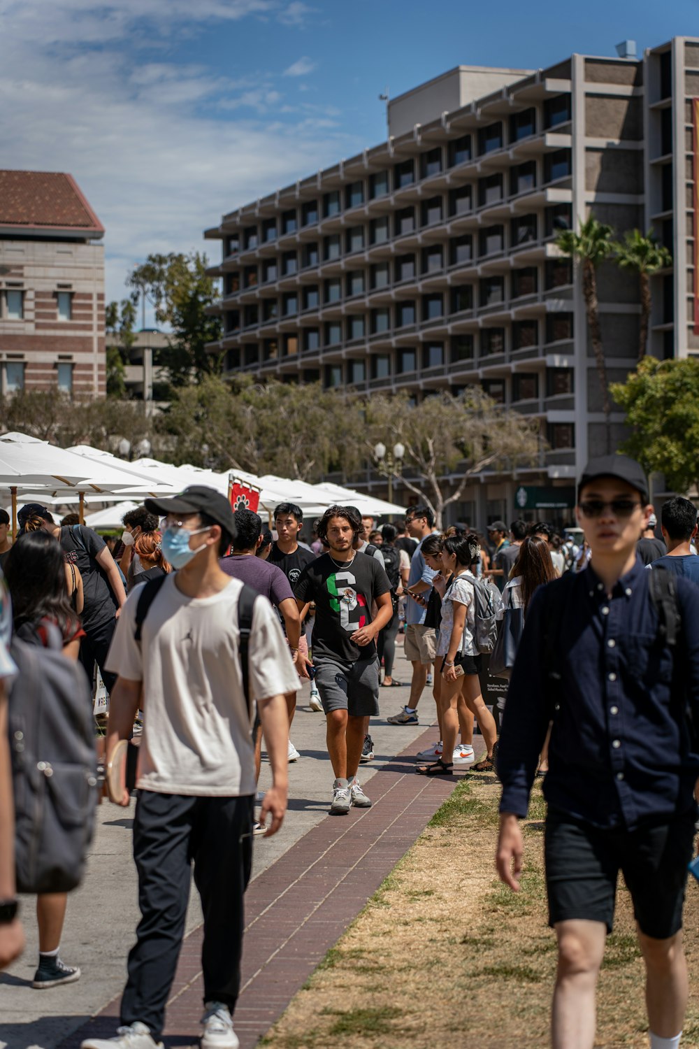 a group of people walking on a street with a building in the background