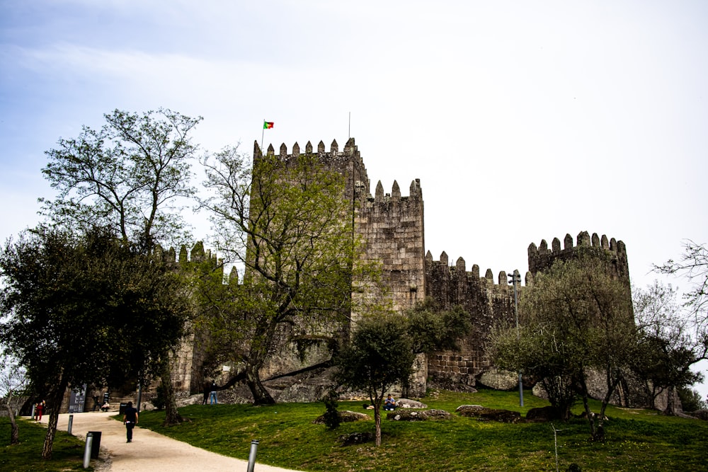 un castillo con árboles y césped con el castillo de Guimarães al fondo