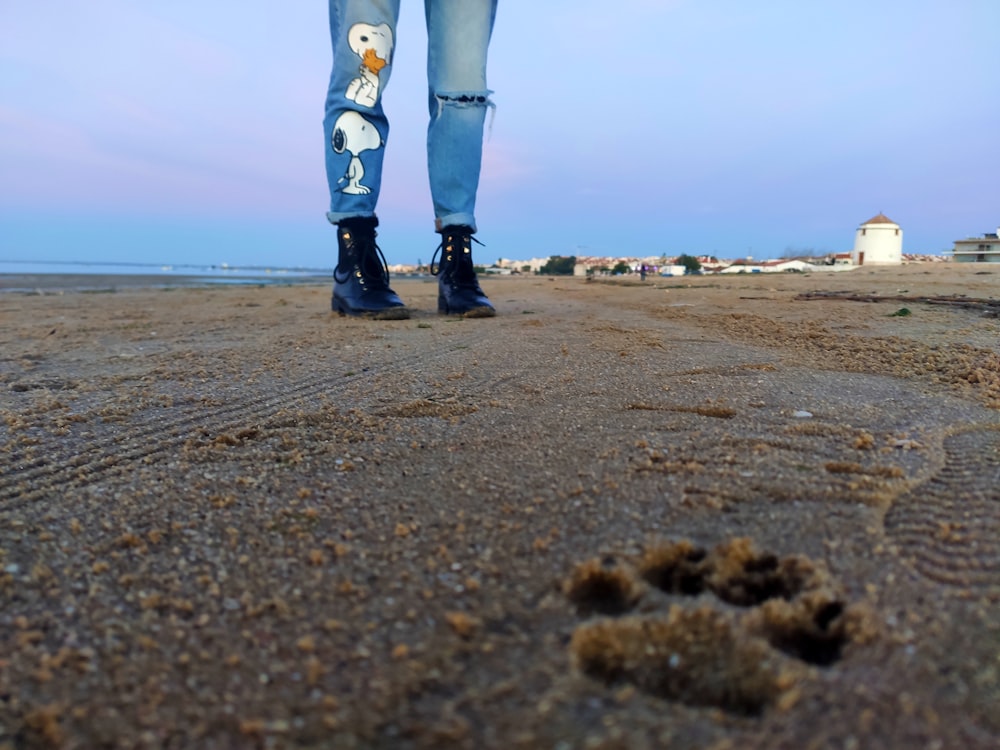 a person's legs and feet on a beach
