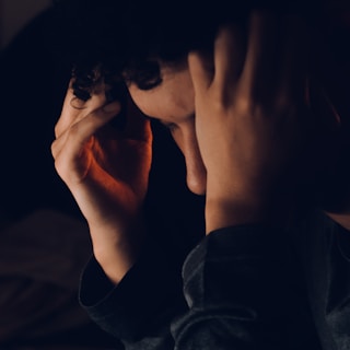 a person holding their hands up to their face