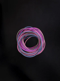 Stack of colorful O-rings in different sizes displayed on a wooden surface.